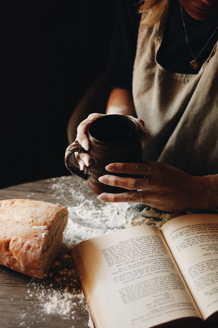 A calming scene of homemade bread and coffee accompanied by an opened recipe book, invoking warmth.